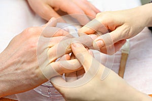 Female hands make manicure for man