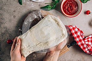 Female hands make pizza. The ingredients for homemade Margherita pizza on stone background.