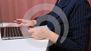 Female hands make a purchase on the Internet using a laptop, payment by card, close-up.