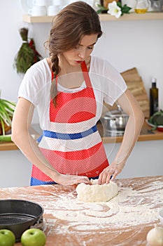 Female hands making dough for pizza or bread on wooden table. Baking concept