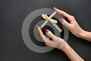 Female hands with manicure holding gift box on dark background