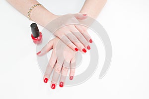 Female hands with manicure and red lacquer on a white table in the beauty salon. closeup of hand of a young woman.