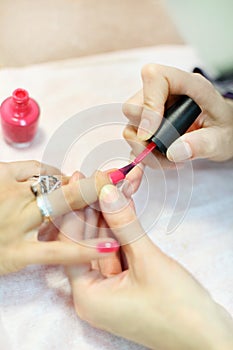 Female hands manicure woman by nail polish