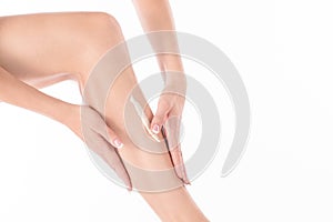 Female hands massage leg of woman with body lotion, close up