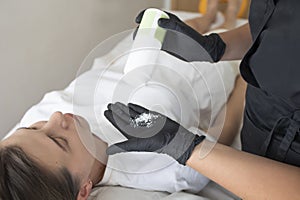 female hands of a master beautician prepare female for the procedure of sugar hair removal