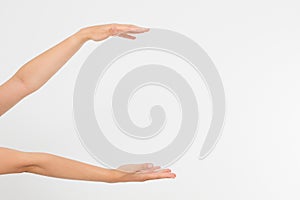 Female hands measuring invisible items, woman`s palm making gesture while showing small amount of something on white isolated bac