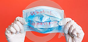 Female hands in medical gloves holding protective mask with what is coronavirus text on it at red background. Health care concept