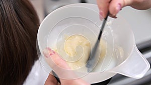 Female hands mixing hair dye.