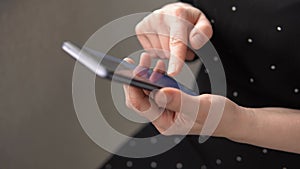 Female hands with mobile phone texting searching something in internet side view