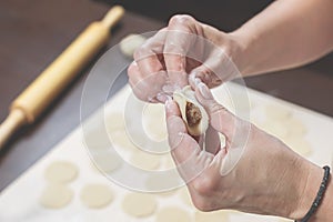 Female hands mold tasty dumplings close-up