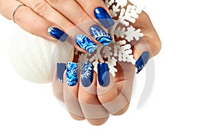 Female hands with New Year design on the nails holding snowflake. photo