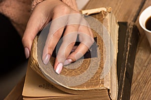 Female hands and an old books.