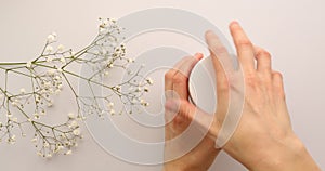 Female hands open jar of green cream or mask with flowers on white background. Luxury green mask cream to the face or body. Concep