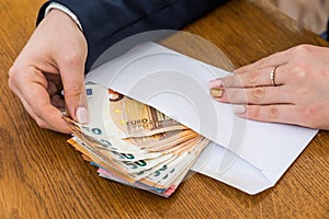 Female hands opening envelope with euro banknotes