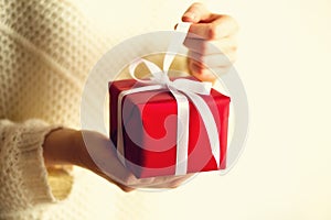 Female hands opening red gift box, copy space. Christmas, new year, birthday party, valentine`s day, mother`s and woman