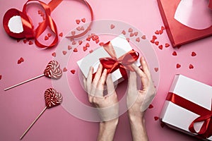 Female Hands Packed Gift For Valentines Day On Pink Background, Top View