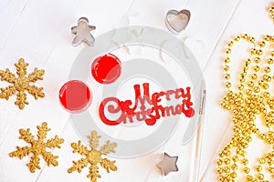 Female hands paint in red and gold dust on the inscription Merry Christmas.Christmas decoration.View top