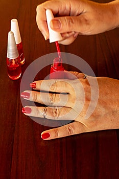Female hands painting their own nails.