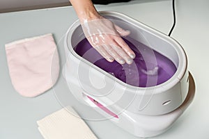 Female hands in a paraffin wax bowl