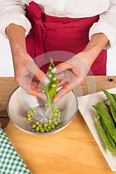 Female hands peeling peas