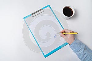 Female hands with pen on document and Cup of coffee. Woman puts signature on paper