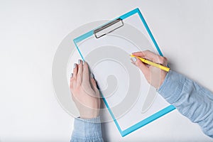 Female hands with pen on document. Woman puts signature on paper. Top view