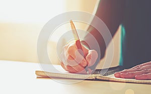 Female hands with pen writing