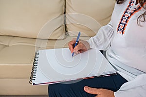 Female hands with pen writing on notebook