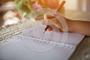 Female hands with pen writing on notebook coffee cafe