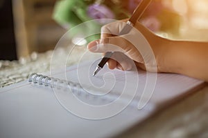 Female hands with pen writing on notebook coffee cafe