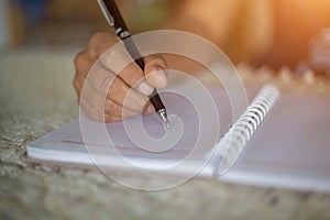 Female hands with pen writing on notebook coffee cafe