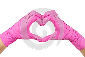 Female hands in pink disposable gloves making a heart shape  on white