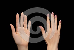 Female hands with pink nail design. Pink nail polish manicure. Woman hands on black background. Both side of female palm on black