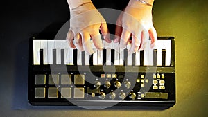 Female hands play on a midi keyboard record music