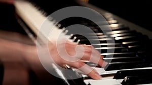 The female hands playing grand piano, closeup