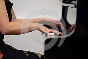 Female hands playing piano, close-up photo