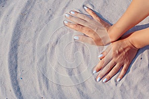 Female hands playing in sand