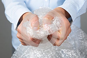 Female hands popping the bubbles of bubble wrap. Stress relief, anger management