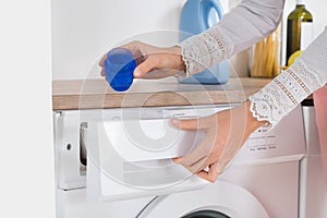 Female Hands Pouring Detergent In The Washing Machine