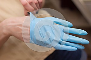 Female hands putting on latex gloves