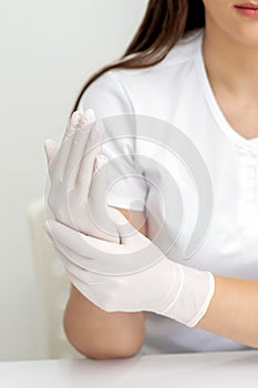 Female hands putting on protective gloves