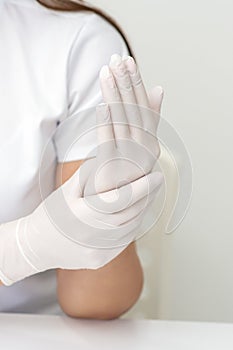 Female hands putting on protective gloves