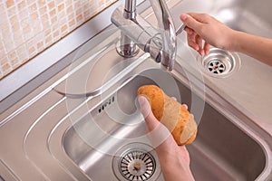 Female hands ready to washing potato in sink in kitchen