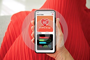 Female hands red dress holding phone app heart and activity