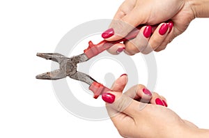 Female hands with red manicure holding pliers isolated on white background