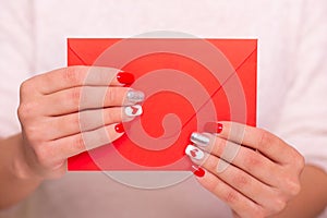 Female hands with red manicure nails, hearts design