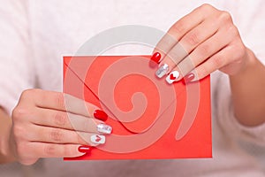 Female hands with red manicure nails, hearts design