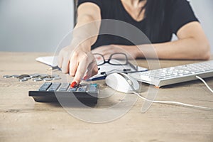 Female hands with red nails on a calculator keyboard