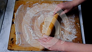 Female hands roll out dough for pies