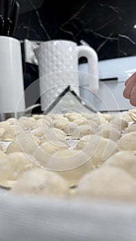 female hands roll out the dough and shape the meat pies in the kitchen